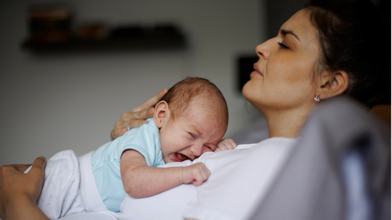 New mom experiencing emotions after childbirth, thinking about postpartum depression vs baby blues.